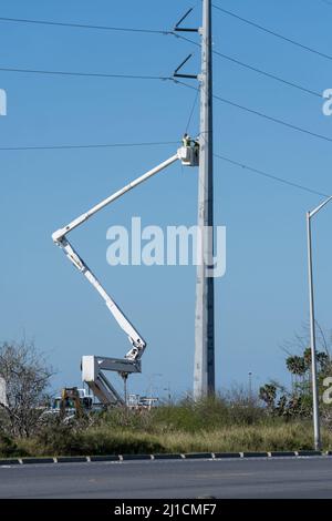 Elektrobauarbeiter oder Linienarbeiter, die in einem erhöhten Eimer arbeiten, um neue elektrische Übertragungsleitungen zu schnur. Stockfoto