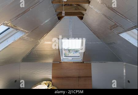 Unvollendete Wohn-Loft Umwandlung mit Silberisolierung Stockfoto