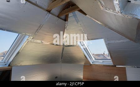 Unvollendete Wohn-Loft Umwandlung mit Silberisolierung Stockfoto