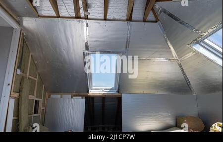 Unvollendete Wohn-Loft Umwandlung mit Silberisolierung Stockfoto