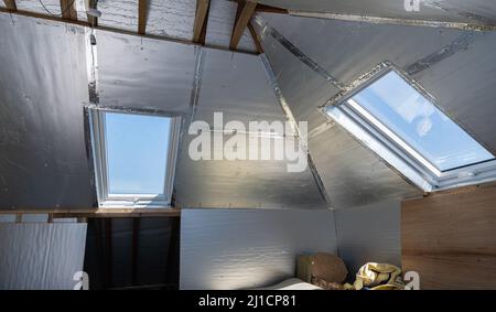 Unvollendete Wohn-Loft Umwandlung mit Silberisolierung Stockfoto