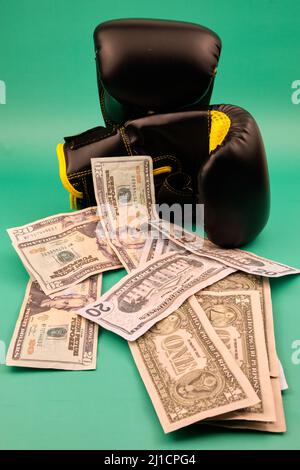 Boxhandschuhe mit viel Dollar auf grünem Hintergrund Stockfoto