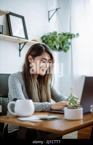 Mexikanische junge Frau arbeitet mit natürlichen Posen in ihrem Heimbüro Stockfoto