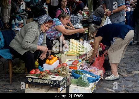 Bild von älteren Kaufleuten und Verkäufern in der ukrainischen Stadt Lemberg, die an Ständen verkaufen und verhandeln, Obst und Gemüse kaufen und verkaufen Stockfoto