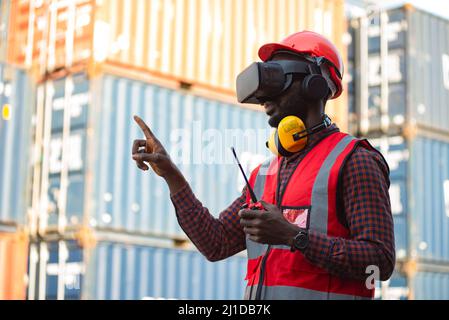 Afroamerikanische Ingenieure mit VR-Headset-Look-Containerschiff. Stockfoto