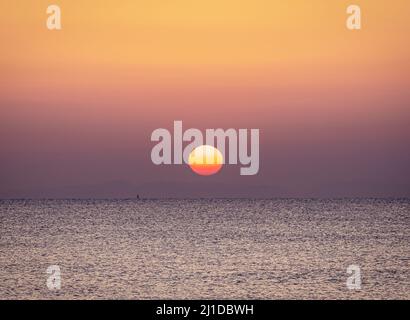 Sonnenaufgang am Strand mit ruhigem Meer Stockfoto