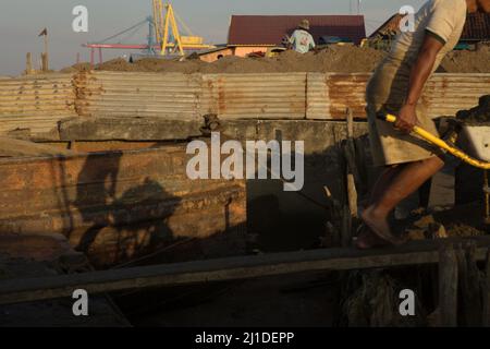 Ein Arbeiter, der Sand am Ufer des Flusses Musi in Süd-Sumatra, Indonesien, entlädt. © Reynold Sumayku Stockfoto