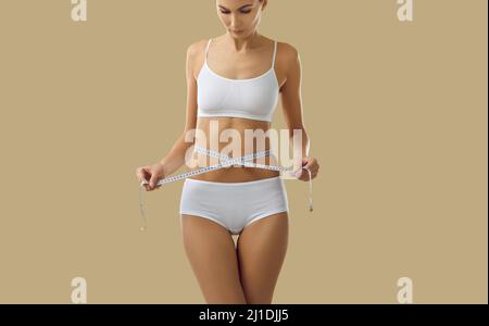 Fit junge Frau, die Diät wurde misst ihre dünne Taille mit Maßband Stockfoto