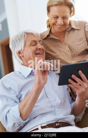 Und so endete der Film Aufnahme eines älteren Mannes, der einen Witz auf seinem digitalen Tablet mit seiner Frau teilt. Stockfoto