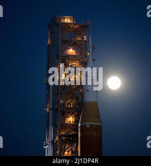 Der Mond steigt hinter der NASA-Rakete Space Launch System (SLS) mit der Orion-Sonde an Bord auf einem mobilen Trägerrakete auf, während er zum ersten Mal am Donnerstag, dem 17. März 2022, im Kennedy Space Center der NASA in Florida zum Launch Complex 39B ausrollt. Vor dem Artemis I-Flugtest der NASA werden die vollständig gestapelte und integrierte SLS-Rakete und die Orion-Raumsonde im Launch Complex 39B einer Nassprobe unterzogen, um die Systeme zu verifizieren und Countdown-Verfahren für den ersten Start zu üben. Foto von Aubrey Gemignani/NASA via CNP/ABACAPRESS.COM Stockfoto