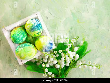 Farbige Eier in Schachtel mit Lilien des Tals auf mintgrünem abstraktem Hintergrund. Ostern. Speicherplatz kopieren Stockfoto