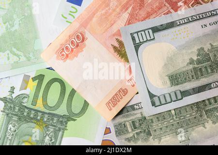 Verschiedene Geldscheine in Banknoten von 100 Euro, 100 Dollar und russischer Rubel als Hintergrund. Blick von oben. Stockfoto
