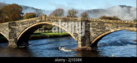 Herbstnebel über der Pont Fawr Bridge eine drei-gewölbte Steinbrücke über den River Conwy im Llanwrst Snowdonia National Park Gwynedd North Wales UK Stockfoto