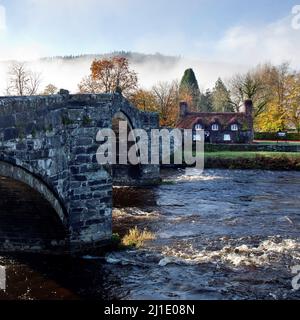 Herbstnebel über der Pont Fawr Bridge eine drei-gewölbte Steinbrücke über den River Conwy im Llanwrst Snowdonia National Park Gwynedd North Wales UK Stockfoto