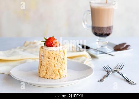 Erdbeer-Holzkuchen auf weißem Hintergrund. Mit heißer Schokolade an der Seite. Nahaufnahme Stockfoto