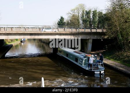 Ein Schmalboot auf dem Grand Union Canal, das unter der Straße A46, Warwick, Warwickshire, Großbritannien, vorbeifährt Stockfoto