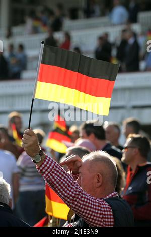 03.10.2021, Deutschland, Brandenburg, Hoppegarten - Mann mit Nationalflagge am Tag der Deutschen Einheit. 00S211003D534CAROEX.JPG [MODELLVERSION: NEIN, EIGENTUM Stockfoto