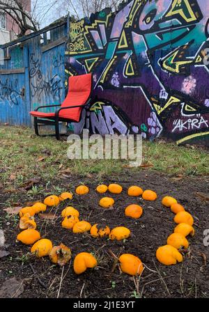 18.12.2021, Deutschland, , Berlin - Smilie aus Orangen vor einer mit Graffiti bedeckten Holzwand. 00S211218D735CAROEX.JPG [MODELLVERSION: NEIN, PR Stockfoto