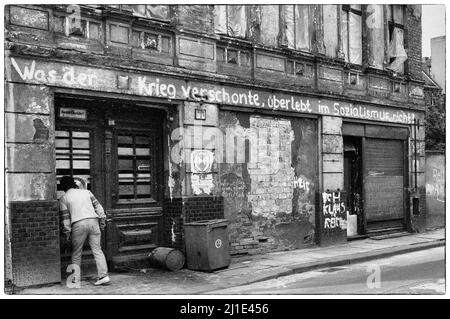 02.04.1990, DDR, , Berlin - Slogan zur Faade eines Wohnhauses: Was der Krieg verschont hat, wird im Sozialismus nicht überleben!. 00S900402D029CAROEX. Stockfoto