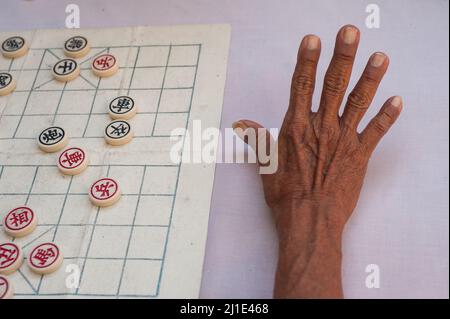 21.01.2018, Singapore, , Singapore - Nahaufnahme zeigt die Hand eines älteren Mannes, der chinesisches Schach auf dem Crete Ayer Square in Chinatown spielt. 0SL180121D010C Stockfoto