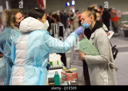 18.03.2022, Deutschland, Berlin, Berlin - Ukrainische Kriegsflüchtlinge, die mit dem Zug ankommen, werden von Freiwilligen am Hauptbahnhof betreut. Eine junge Frau bekommt Stockfoto
