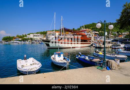 28.08.2021, Griechenland, Ostmakedonien und Thrakien, Limenas - Fischerboote und ein Ausflugsschiff im Hafen von Limenas. Die Hauptstadt der Insel Thas Stockfoto