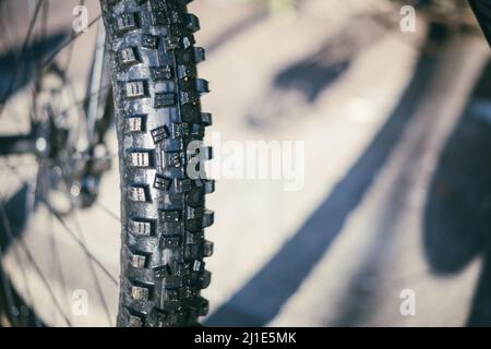 Schwarzer Gummireifen mit großen Knöpfen von einem Mountainbike aus nächster Nähe Stockfoto