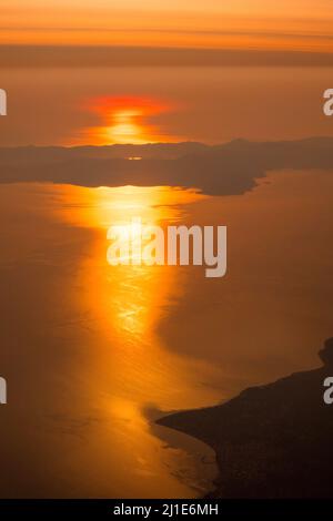 Luftaufnahme von Sonnenuntergang oder Sonnenaufgang, Sonnenberge Silhouette, aus dem Flugzeug geschossen, Athen, Griechenland Stockfoto