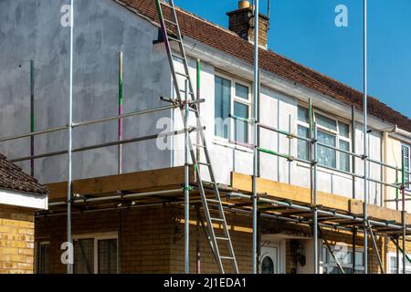 Ein Haus, das mit Gerüsten bedeckt ist, um einen einfachen und sicheren Zugang zu ermöglichen, damit es von außen neu gestrichen werden kann. Stockfoto