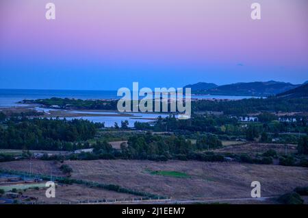 Farbenfroh leuchtender Abendhimmel über den Bergen Sardiniens in Italien. Farbenprächtiger Sonnenuntergang über Feldern und kleinen Dörfern Sardiniens Stockfoto