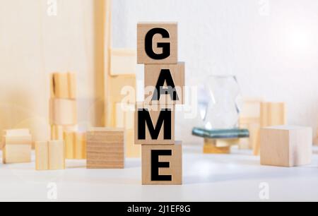 Spielwort, das mit unterschiedlich farbigen Buchstabenblocks geschrieben wurde, die auf einem dunklen Hintergrund angeordnet sind Stockfoto