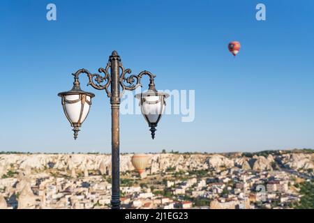 Blick auf eine Straßenlampe gegen einen Heißluftballon am blauen Himmel von kappadokien. Stockfoto