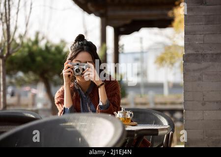 Junge Dame fotografiert im Straßencafé - Stock Foto Stockfoto