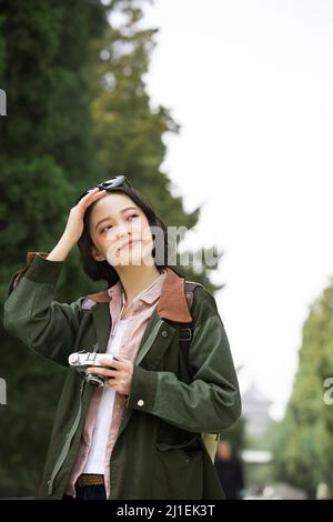 Lächelnde junge Frau, die Augen abschirmt - Stock Foto Stockfoto