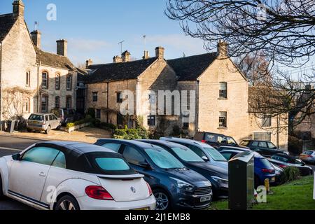 Zu viele Autos parkten an der Straße außerhalb der typischen Cotswold Stone Cottages, Tetbury, Gloucestershire, Großbritannien Stockfoto