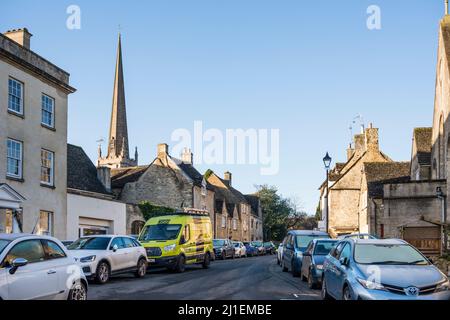 Zu viele Autos parkten an der Straße außerhalb der typischen Cotswold Stone Cottages, Tetbury, Gloucestershire, Großbritannien Stockfoto