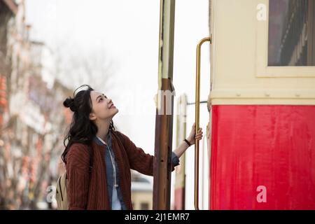 Junge weibliche Touristen, die sich vorbereiten, eine alte Straßenbahn zum Sightseeing zu besteigen - Stock photo Stockfoto