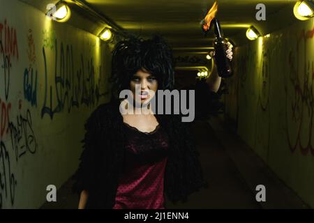 Eine freakige Frau mit einer Benzinbombe in den Händen Stockfoto