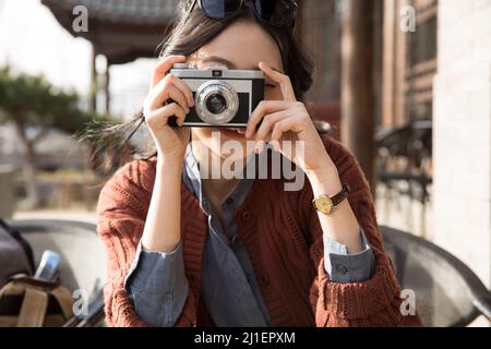 Junge Dame fotografiert im Straßencafé - Stock Foto Stockfoto