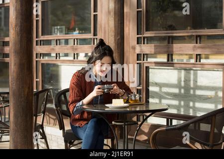 Junge Dame fotografiert im Straßencafé - Stock Foto Stockfoto