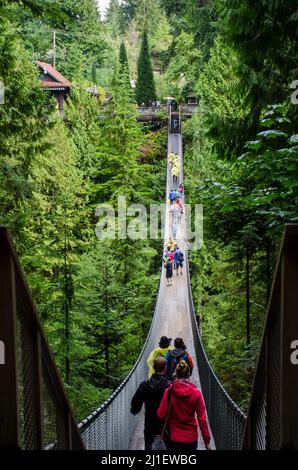 Capilano Hängebrücke an einem überfüllten Tag in Vancouver, BC, Kanada. Hängebrücke zwischen üppig grünen Bäumen mit vielen Touristen zu Fuß. Stockfoto
