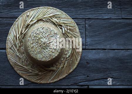 Strohhut gegen eine alte Holzoberfläche Stockfoto