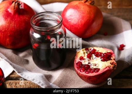 Glas Granatapfelmelasse und frisches Obst auf dem Tisch Stockfoto