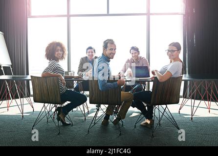 Treffen von gleichgesinnten Fachleuten. Porträt einer Gruppe von Bürokollegen, die um einen Sitzungstisch sitzen. Stockfoto