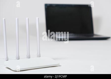 Laptop und wi-Fi-Router auf weißem Hintergrund. Internetverbindung. Stockfoto