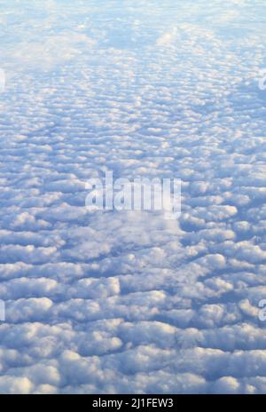 Unglaubliche Aussicht auf das Wolkenmeer während des Fluges vom Flugzeugfenster Stockfoto