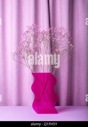 Getrockneter Blumenstrauß in rosa Vase auf violettem, violettem Hintergrund. Inneneinrichtung. Hochwertige Fotos Stockfoto