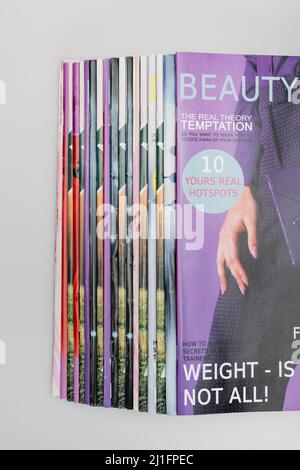 Draufsicht auf Beauty-Magazine, isoliert auf Grau gestapelt Stockfoto