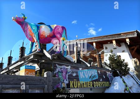 Mehrfarbige Modellkuh vor strahlend blauem Himmel: Das Logo des Restaurants Kuhtaier Dorfstadl im Skigebiet Kuhtai, Tiroler Alpen, Österreich Stockfoto