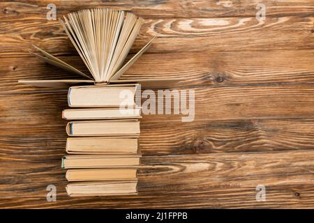 Draufsicht auf Bücher auf texturierter Holzfläche mit Kopierfläche Stockfoto